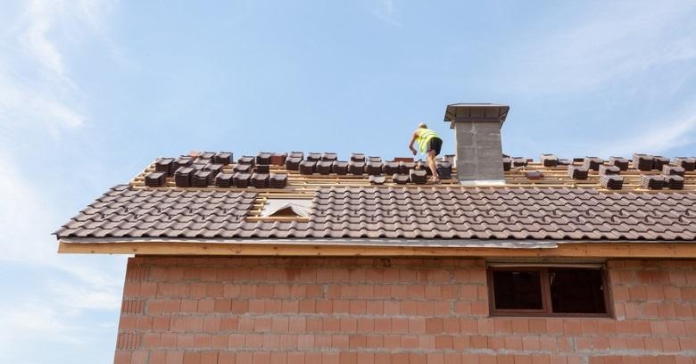 Roofers installing new roof tiles on a residential house in The Woodlands, Texas.