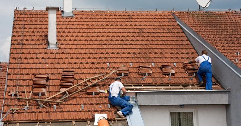 Roofers working on a red tiled roof in The Woodlands Texas.